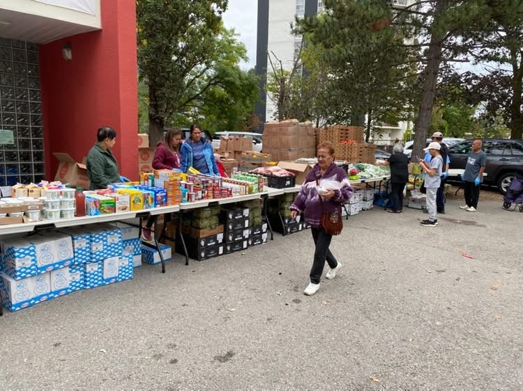 Long tables filled with all kinds of food - bread, vegies, fruit, snacks - and volunteers behind the tables and a person walking in front