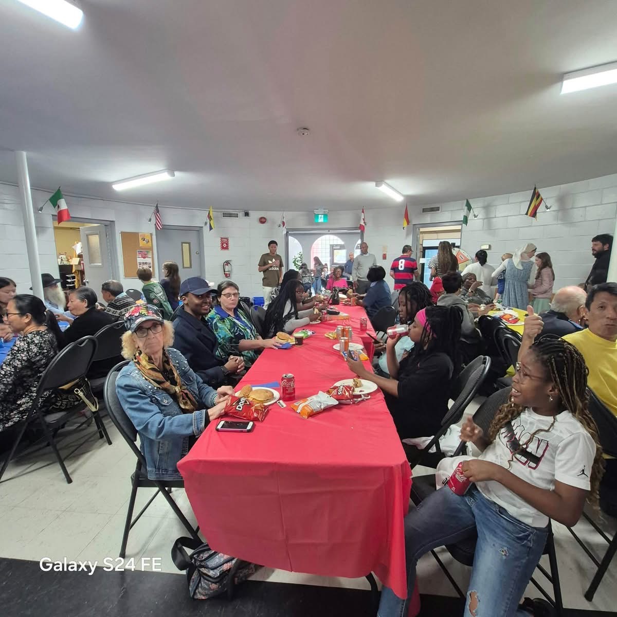 Many people sitting around long tables talking and eating